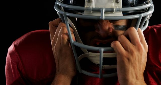 Focused American Football Player Wearing Helmet Under Dramatic Lighting - Download Free Stock Images Pikwizard.com