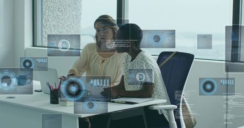 Two Professionals Analyzing Data with Futuristic Graphics at Corporate Office