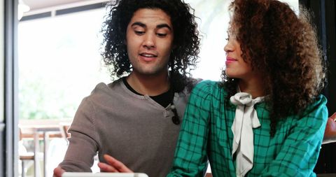 Couple using digital tablet at restaurant