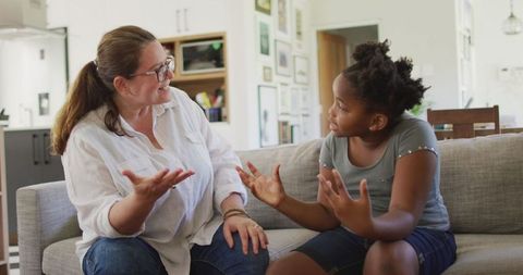 Caucasian Mother Discussing with African American Daughter in Living Room