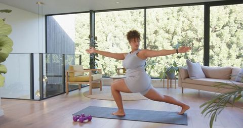 Woman Practicing Yoga in Bright Modern Living Room Interior