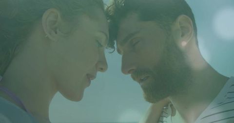 Sunlit romance leaning foreheads touching couple gazing tenderly in pastel summer light