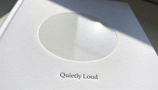 Minimal White Hardcover Featuring Glossy Embossed Circle and Quietly Loud Serif Title