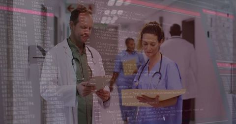 Doctor and nurse reviewing digital patient data with code overlay in hospital corridor