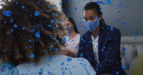 Masked healthcare provider conducting patient consultation with blue viral particle overlay