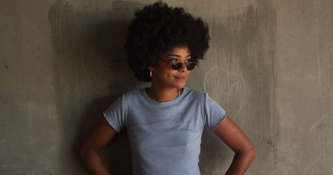 Trendy Young Woman with Sunglasses Posing Against Urban Wall