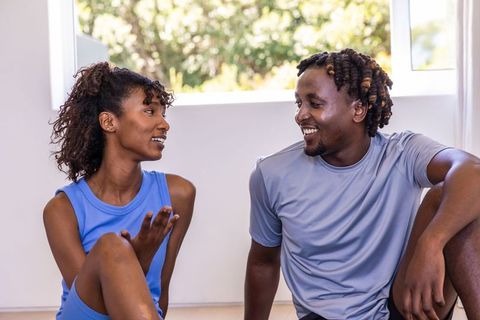 African american couple conversing after workout in sunlit home fitness studio