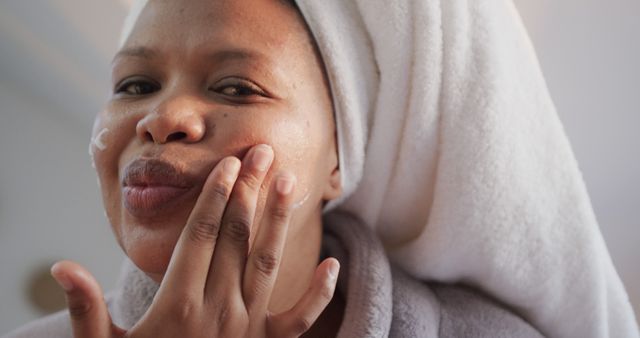 Woman in Towel Applying Skincare Cream on Face - Download Free Stock Images Pikwizard.com