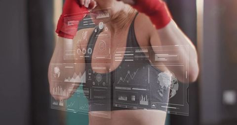 Mid-adult woman punching with red wraps training with ar fitness interface
