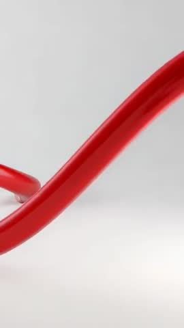 Vertical loop video of glossy red ribbon sweeping across pale minimal studio space
