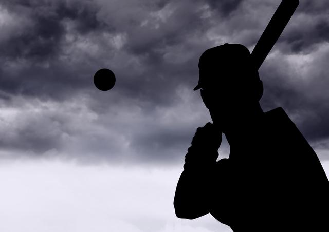 Silhouette of a baseball player preparing to hit the ball against a dark, cloudy sky. Suitable for use in sports-related designs, dramatic athletic event promotions, motivational posters, and content showing resilience and focus.