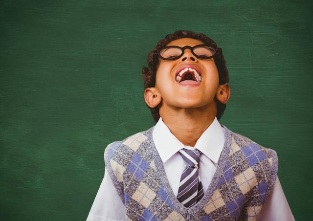 Cheerful School Boy Laughing in Classroom Against Green Chalkboard - Download Free Stock Photos Pikwizard.com