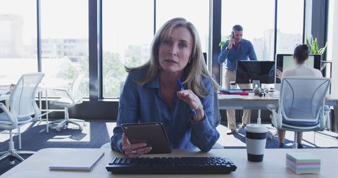 Confident Businesswoman Using Tablet in Modern Open Workspace