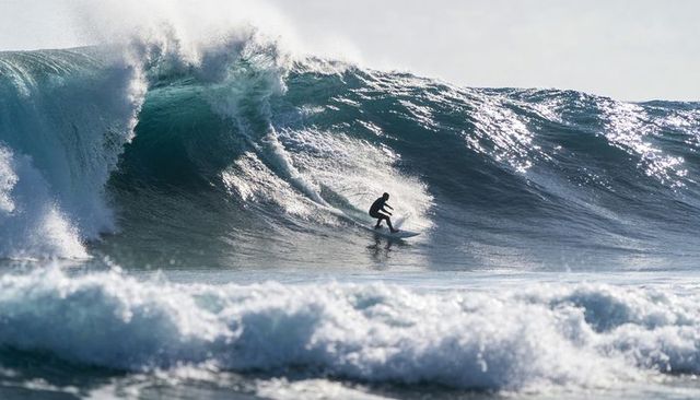 Surfer Carving Down Massive Teal Wave, Sunlit Ocean Power and Spray
