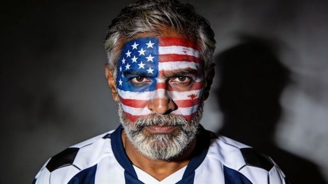 Senior man with full-face american flag paint wearing sports jersey, dramatic portrait
