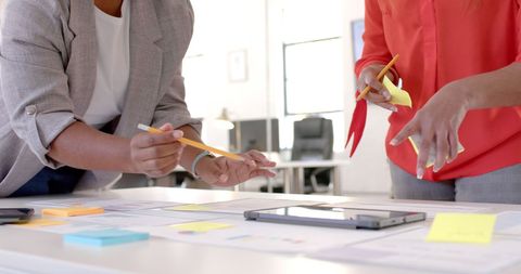 Diverse Businesswomen Collaborating with Notes and Tablet in Office