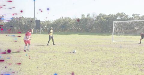 Soccer player taking penalty on sunny grass pitch with goalkeeper preparing and referee watching