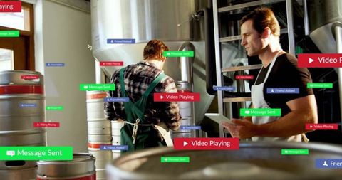 Brewery workers connecting through technology in industrial setting