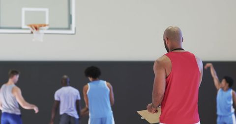 Basketball Coach Observing Players Training on Indoor Court