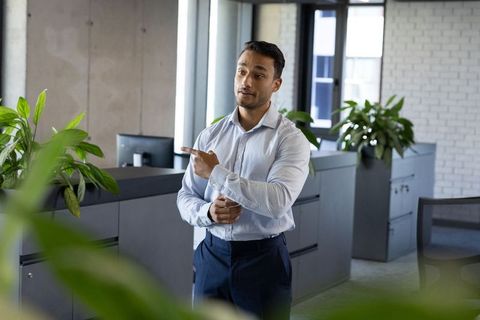 Confident Professional Discussing Ideas in Modern Office Environment