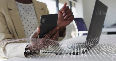 Business Professional Analyzing Data on Smartphone and Laptop