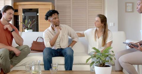 Supportive friends discussing emotions during friend's gathering