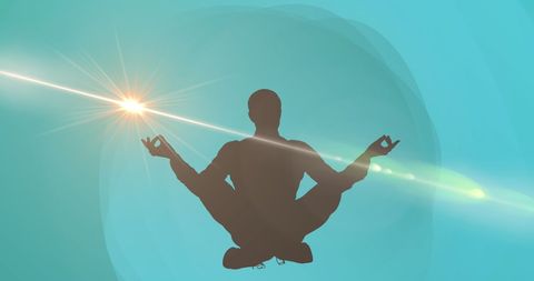 Silhouette Meditating in Lotus Pose with Ethereal Light Burst