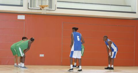 High school basketball players lining up for free throw in indoor gymnasium, team play