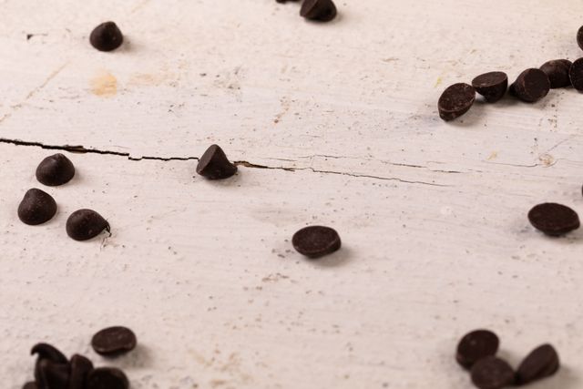 Close-up of chocolate chips on white table, copy space - Download Free Stock Photos Pikwizard.com