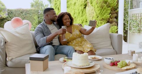 Couple Celebrating Special Occasion with Champagne and Cake on Patio