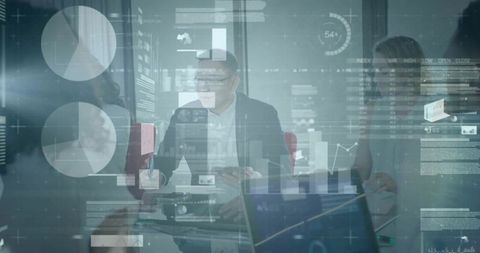 Executive presenting HUD data overlays in glass conference room with laptops and charts