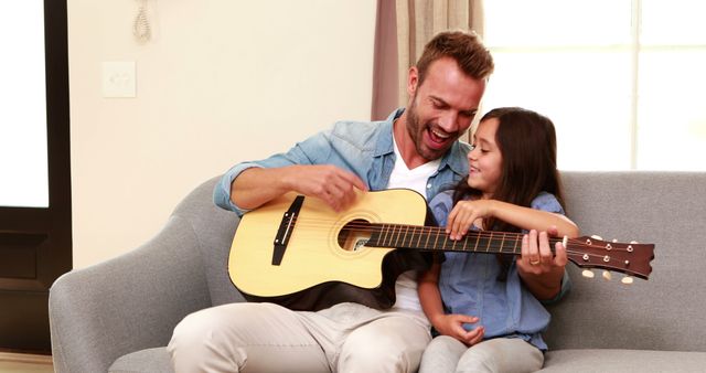 Smiling Father Teaching Daughter to Play Acoustic Guitar on Sofa - Download Free Stock Images Pikwizard.com