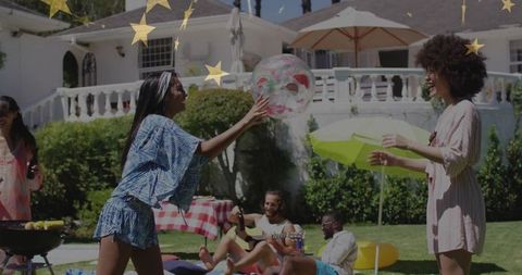 Friends enjoying garden party with clear beach ball and picnic