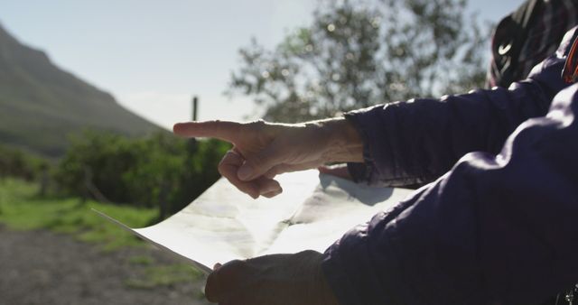 Person in Purple Jacket holding Map Pointing in Outdoor Landscape - Download Free Stock Images Pikwizard.com