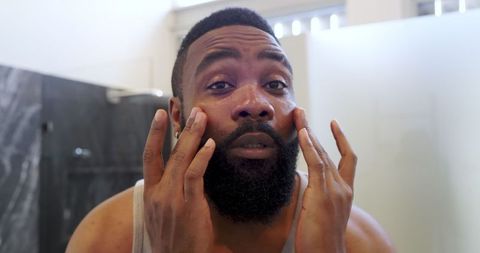 Man Applying Facial Moisturizer in Modern Bathroom for Skincare Routine