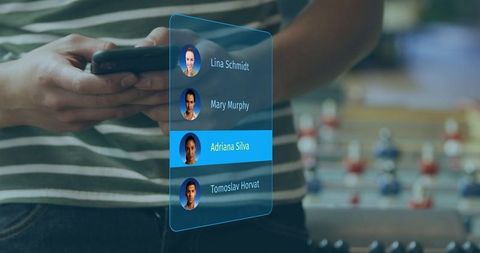 Using smartphone with holographic contacts interface in casual lounge with foosball