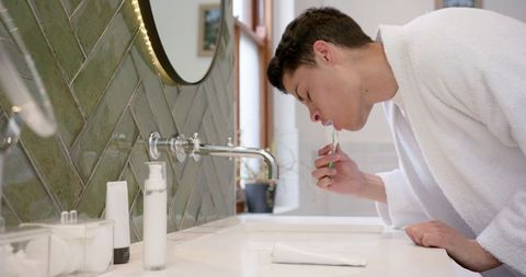 Man Practicing Morning Dental Hygiene in Bright Bathroom