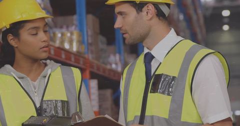 Warehouse Workers Discuss Logistics Amidst Digital Processing