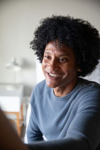 Smiling Man with Natural Hair Relaxes Comfortably in Bedroom