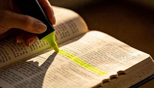 Hand Highlighting Vintage Book Passage with Yellow Highlighter Closeup for Study Notes