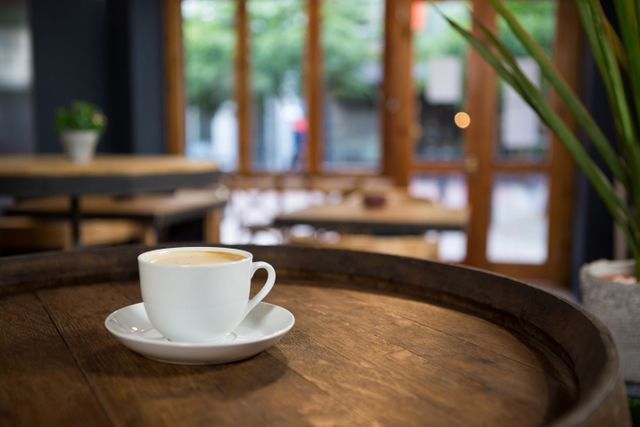 Cup of coffee on wooden table at cafeteria