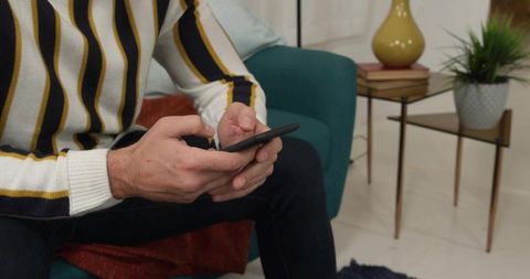 Man Relaxing with Smartphone on Cozy Living Room Sofa