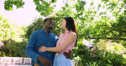 Happy Multiracial Couple Embracing in Sunlit Garden