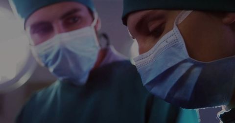 Focused Surgeons Performing Operation Under OR Light