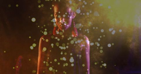 Silhouetted performer amidst mystical smoke and bokeh lights