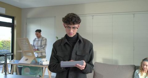 Young professional holding tablet while collaborating in stylish home office living room
