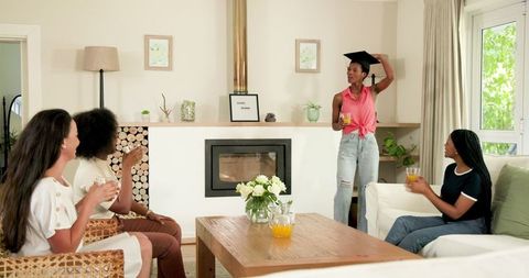 Friends Celebrating Graduation with Joyful Toasts and Smiles at Home