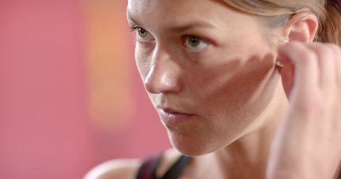 Focused Woman Tucking Hair Behind Ear in Preparation