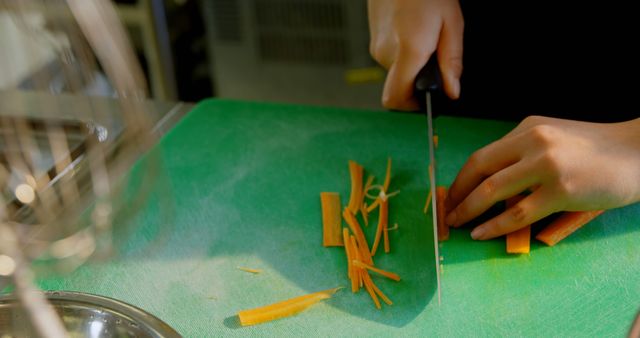 Closeup of Person Slicing Carrots on Green Cutting Board in Kitchen - Download Free Stock Images Pikwizard.com