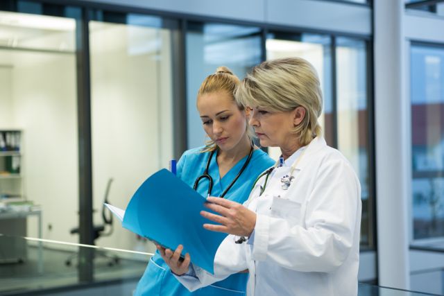 Female doctor and nurse looking at a medical report in hospital